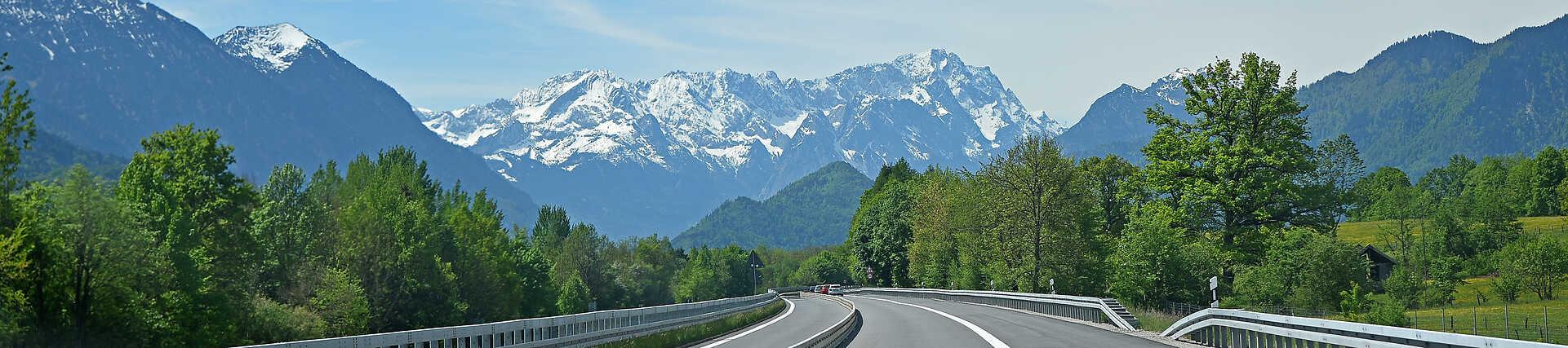 Roadtrip in Süddeutschland mit kurviger Straße, Bergen und Wald.