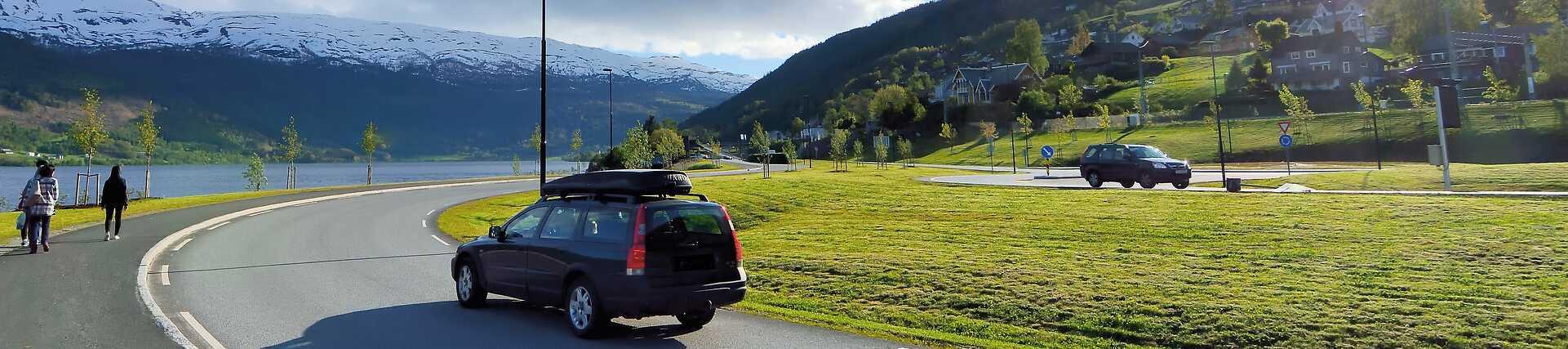 Auto fährt auf einer malerischen Straße in Norwegen entlang der Küste.