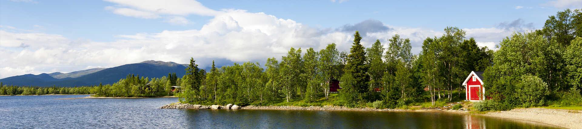 Rotes Schwedenhaus in Skandinavien vor einem Waldhintergrund.