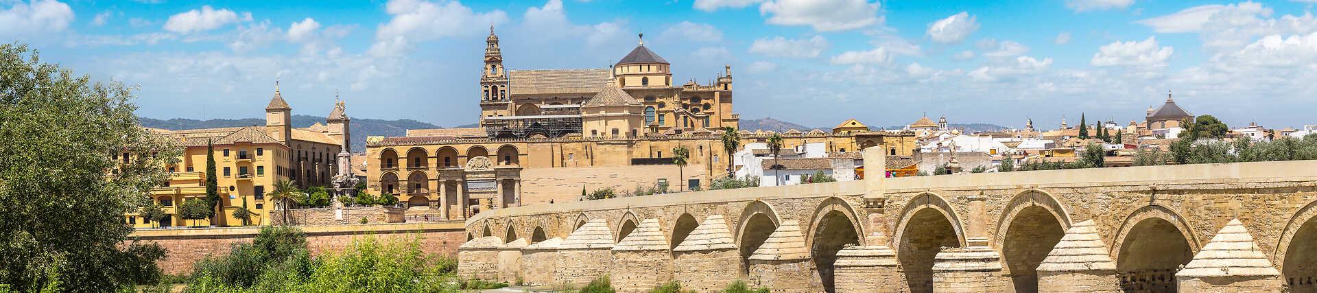 Panoramabild der historischen Römischen Brücke über den Fluss Guadalquivir mit Blick auf die beeindruckende Moschee-Kathedrale in der Altstadt von Córdoba, Spanien.