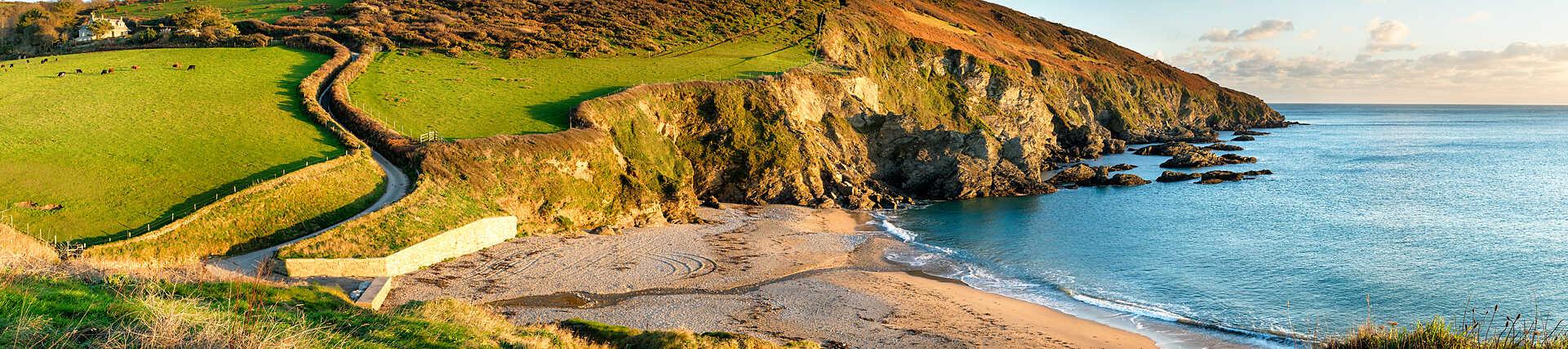 Roadtrip in Südengland: Auto auf kurviger Straße mit grüner Landschaft.