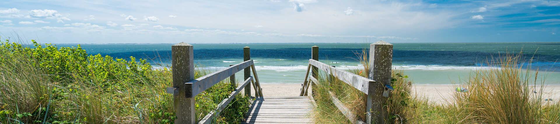 Roadtrip entlang der niederländischen Küste: Strand, Dünen und ein Mietwagen.
