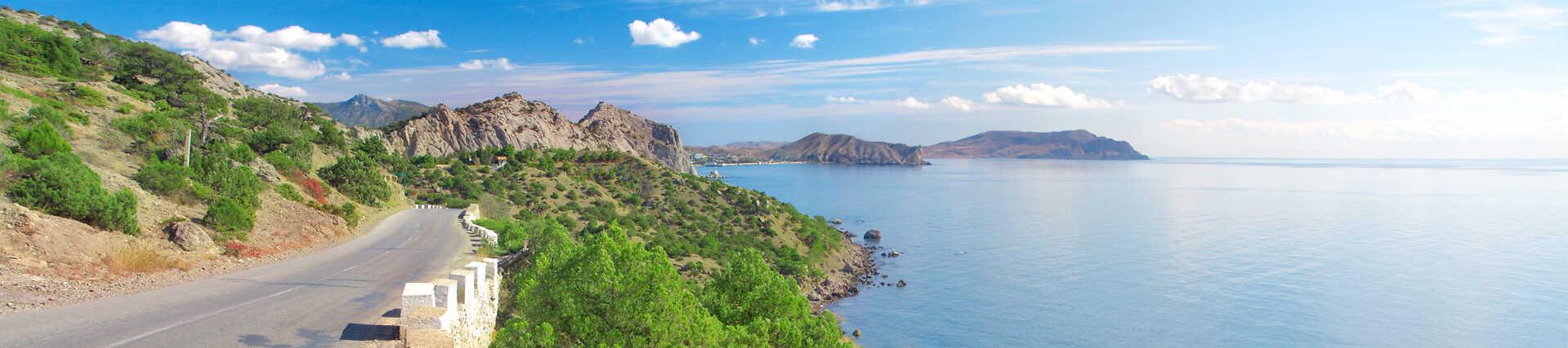 Kreta Rundreise: Malerische Küstenstraße bei Sonnenschein.