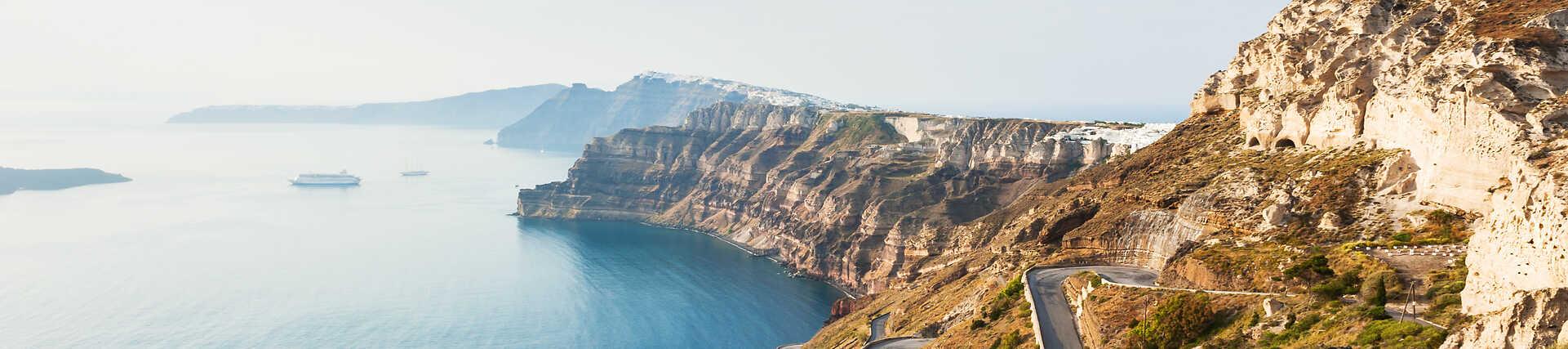Santorini, Griechenland: Weiße Häuser mit blauen Kuppeln und Blick auf die Caldera.