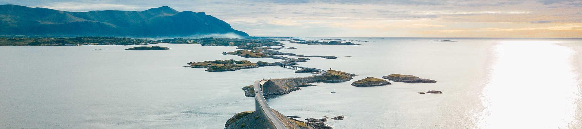 Luftaufnahme der ikonischen Storseisundet-Brücke auf der Atlantikstraße (Atlanterhavsveien) in Norwegen, die kleine Inseln im offenen Atlantik verbindet.