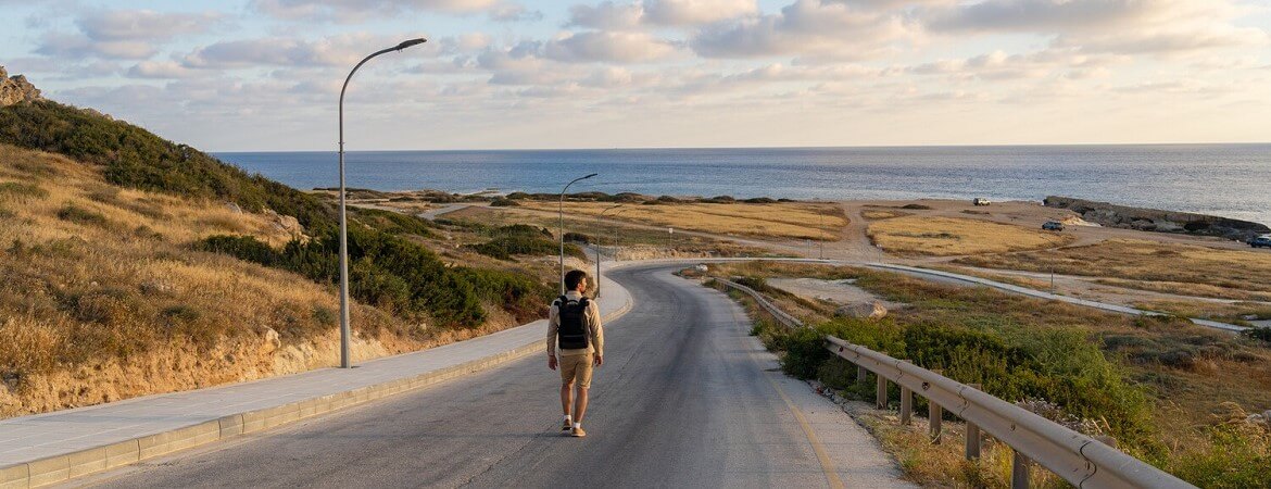 Mann läuft an einen Küstenstraße im Westen von Zypern entlang