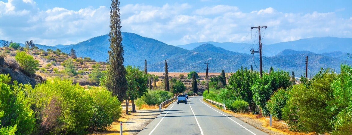 Auto fährt durch eine Berglandschaft auf Zypern