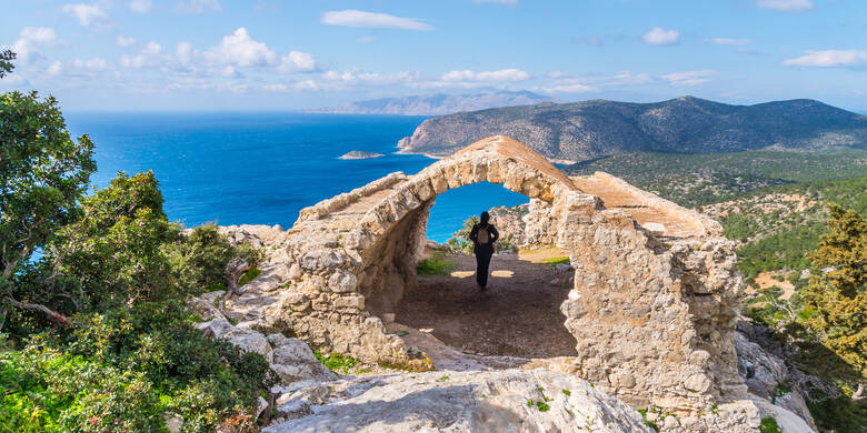 Frau schaut auf die Berge und das Meer auf Rhodos