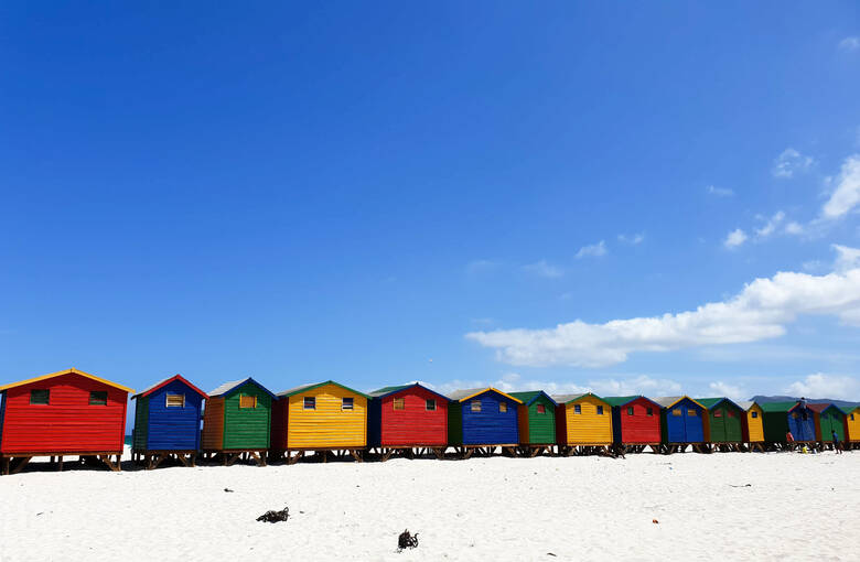 Bunte Hütten an einem Strand in Südafrika