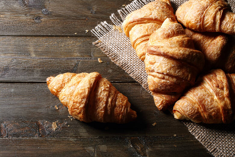 Croissants liegen auf einem Holztisch