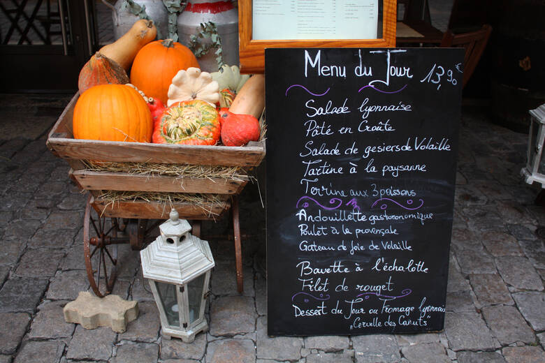 Tafel und Kürbisse vor einem Restaurant in Lyon
