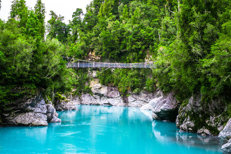 Hängebrücke über blauem See in Neuseeland 