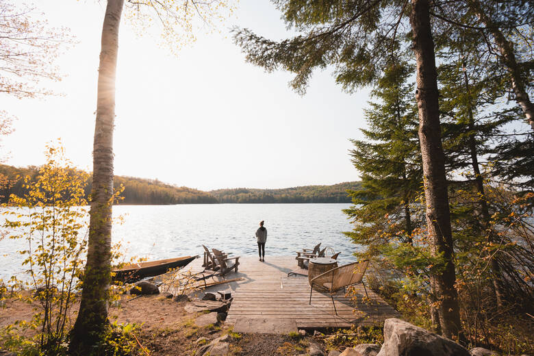 Frau steht an einem See in Kanada
