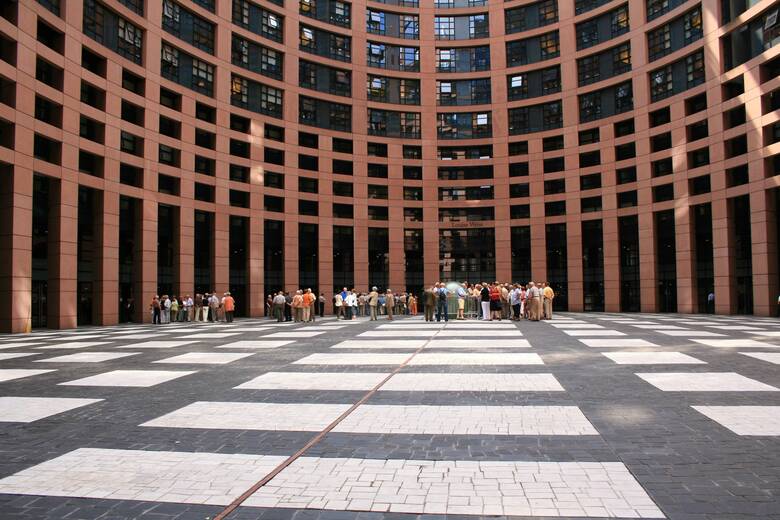 Menschen stehen vor dem Europaparlament in Straßburg