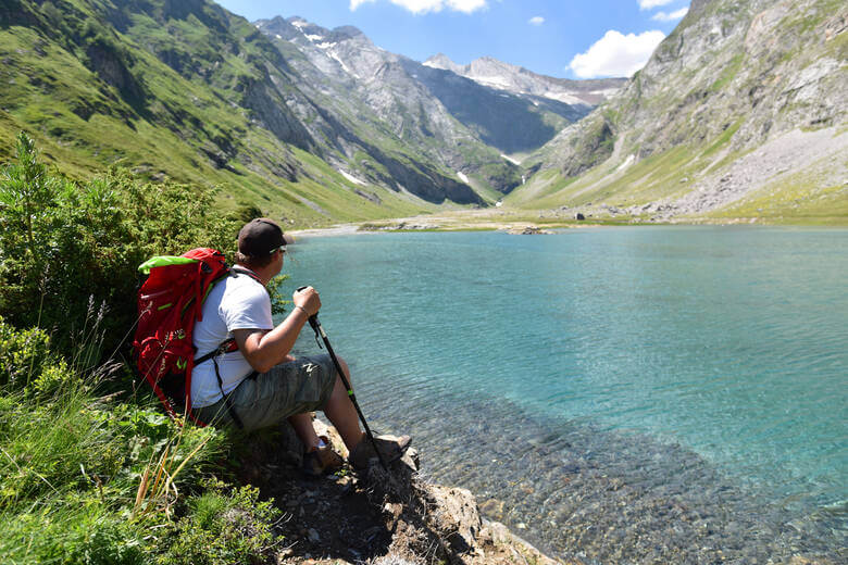 Wanderer ruht sich an einem See in den Pyrenäen aus