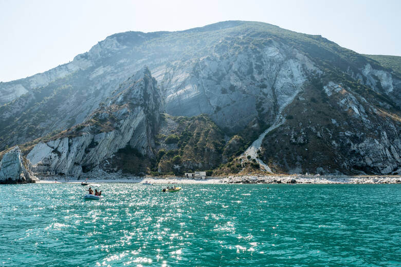 Glasklares Wasser und Klippen an einem Strand in Italien 