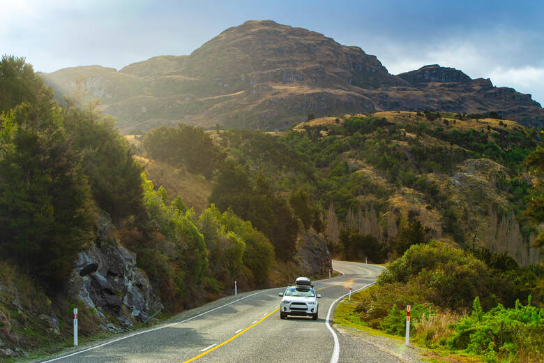 Auto fährt durch Berglandschaft in Neuseeland 