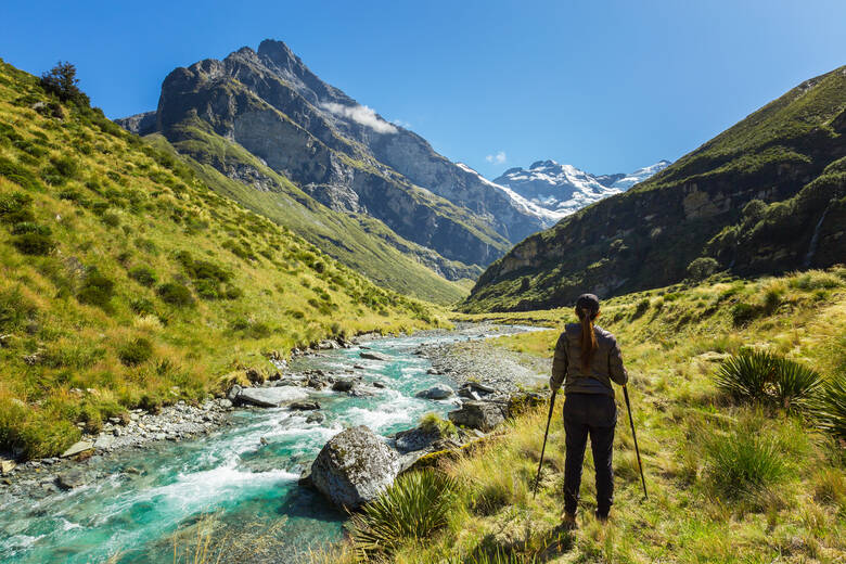 Frau wandert durch Landschaft in Neuseeland 