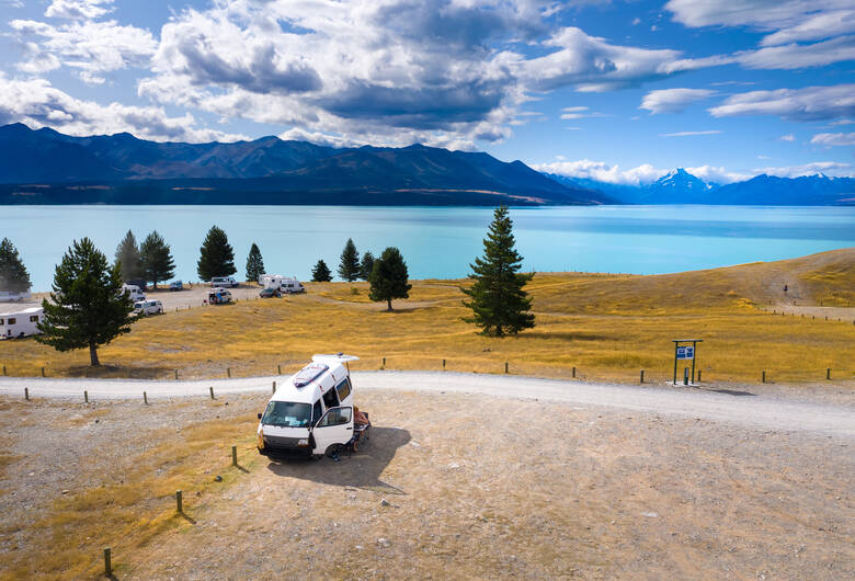 Camper steht vor dem türkisfarbenen Lake Tekapo in Neuseeland