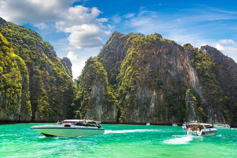Boote fahren über das Meer in der Maya Bay in Thailand 