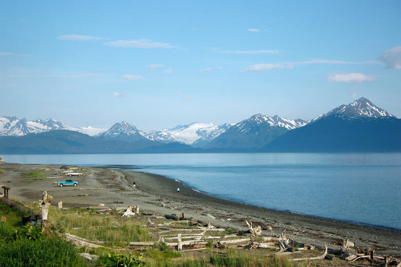 Autos stehen am Strand von Homer mit Blick auf die Berge