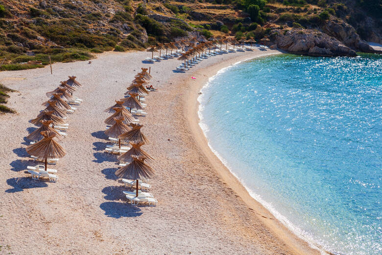 Sonnenschirme und Liegestühle am Strand von Oprna in Kroatien