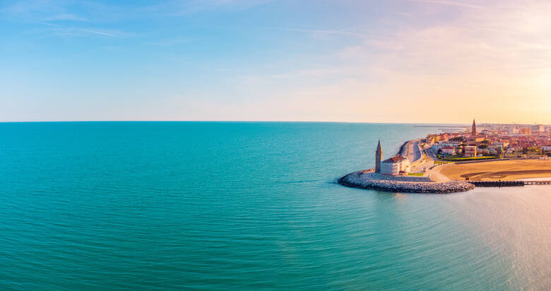 Sonnenuntergang über der italienischen Stadt Caorle und dem Meer