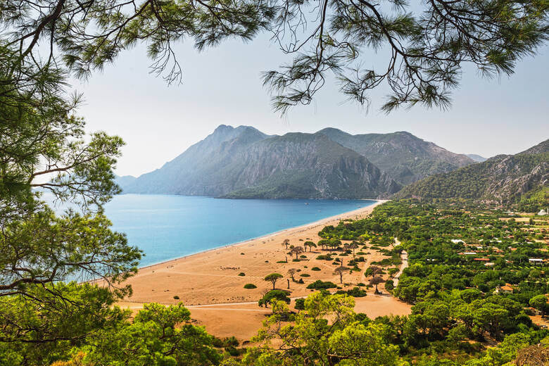 Blick auf einen Strand, das Meer und Berge in der Türkei