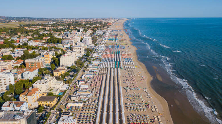 Strand und Hochhäuser zwischen Pinien in Rimini