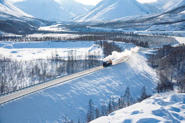 Eisenbahn fährt durch schneebedeckte Berge in Sibirien