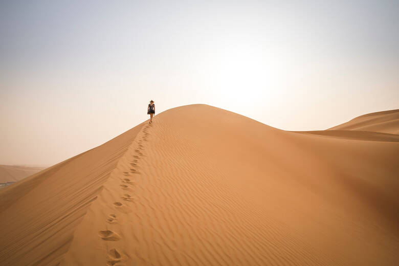 Frau läuft über eine Sanddüne in der Wüste Rub al Khali
