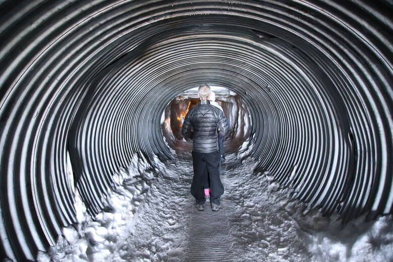 Mann blickt in eine Eishöhle in Island 