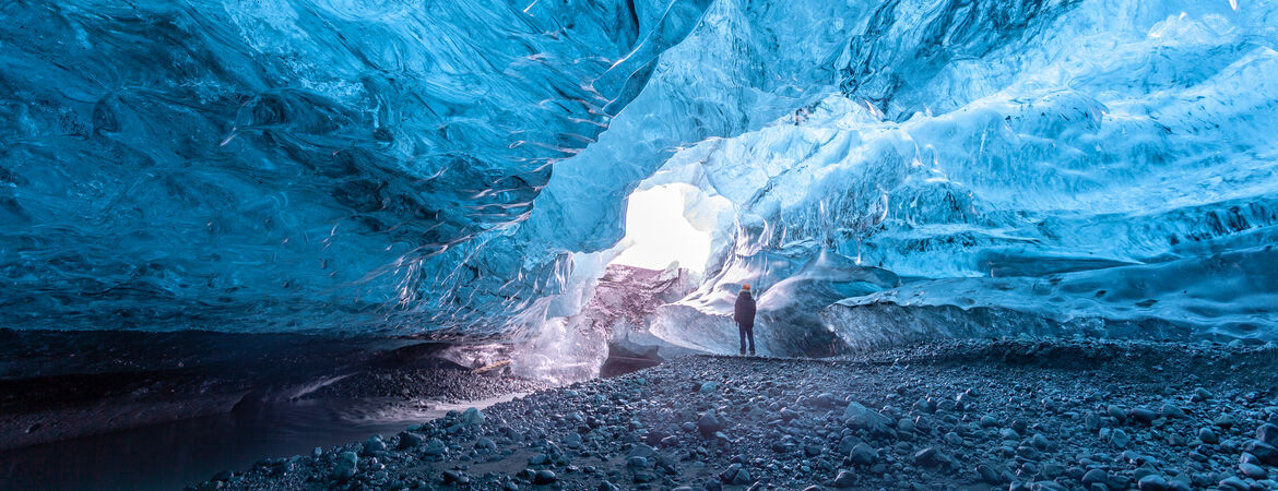 Person steht in einer Eishöhle in Island