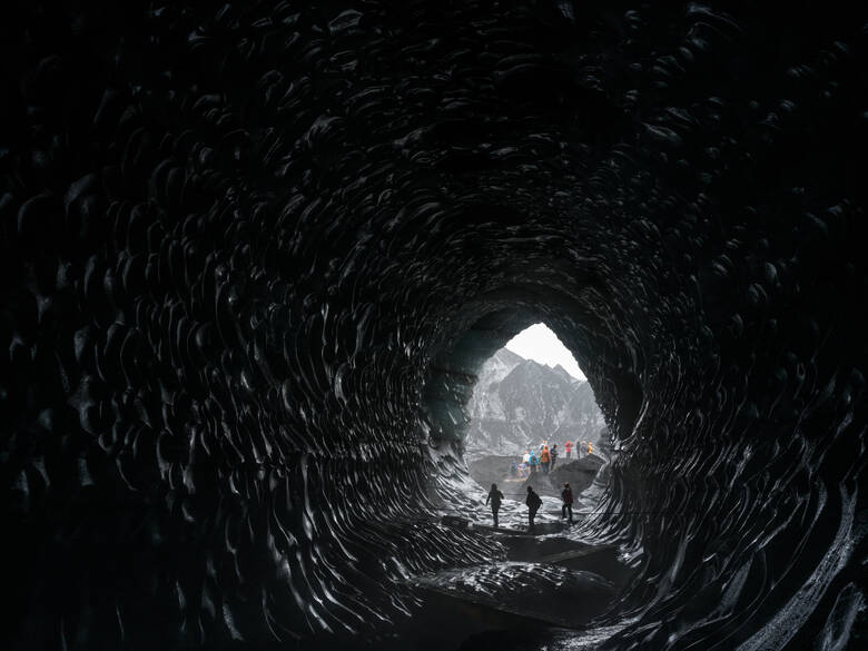 Touristen in einer Eishöhle in Island 