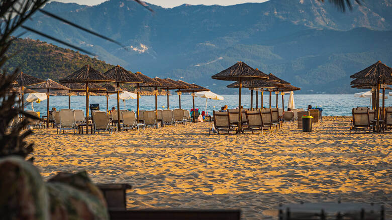 Schirme und Sonnenliegen an einem Strand auf Makedonien
