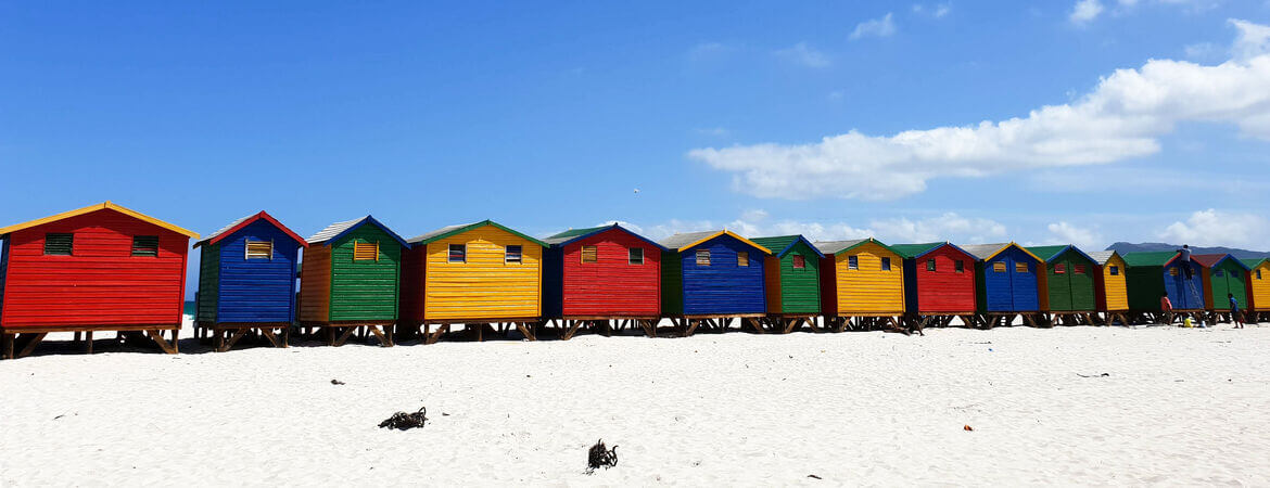 Bunte Häuser an einem Strand in Kapstadt