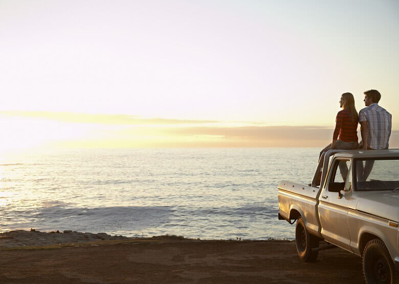 Paar mit Auto am Strand