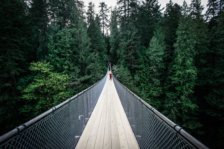 Frau steht auf einer Hängebrücke in Kanada