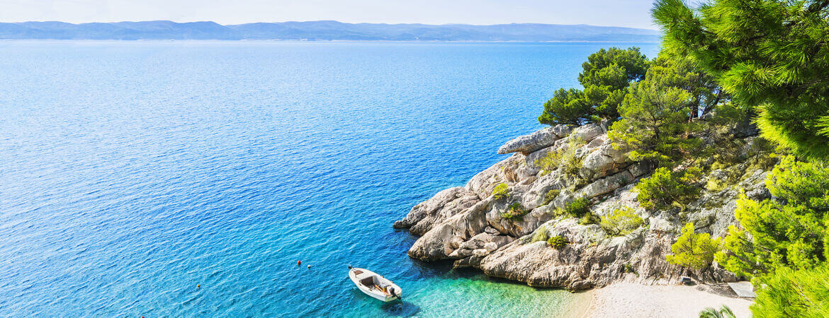 Boot in türkisfarbenen Wasser an der Küste von Kroatien