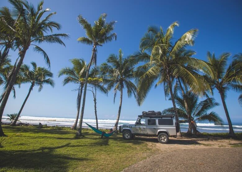 Auto steht unter Palmen an einem Strand in Costa Rica