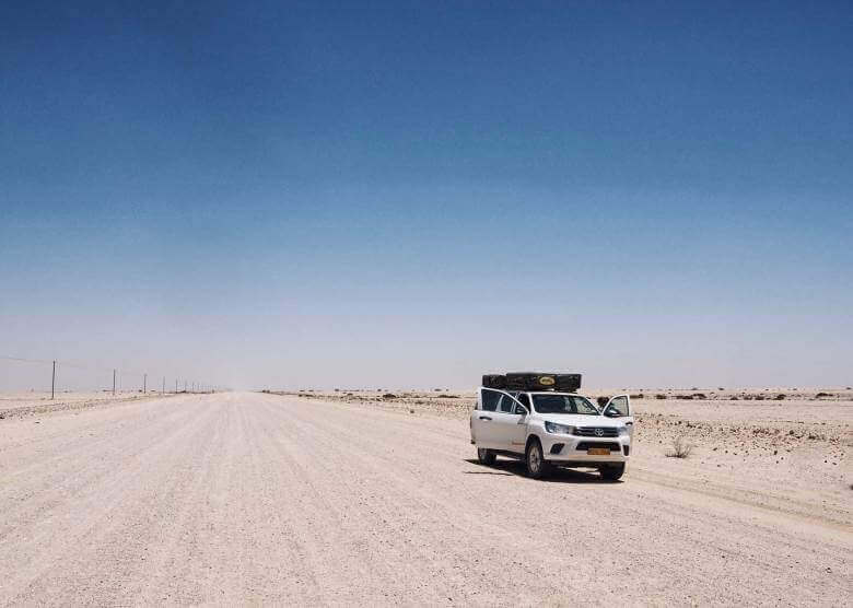 Auto fährt durch die Wüste Namibias