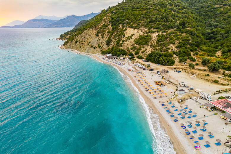 Liegen und Sonnenschirme am Strand von Bunec in Albanien