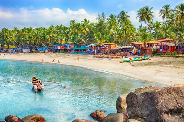 Palmen und Boote am Strand in Goa in Indien 