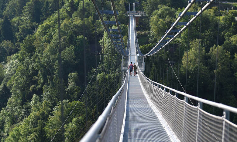 Zwei Menschen laufen über eine riesige Hängebrücke im Harz