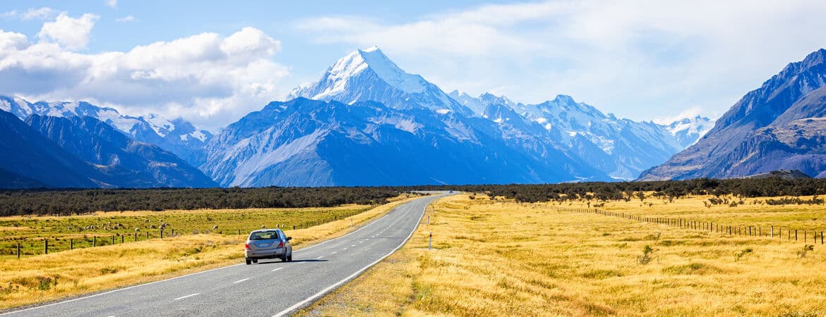 Auto fährt durch neuseeländische Landschaft