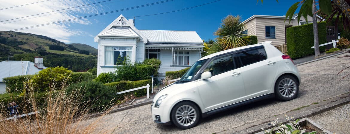 Auto fährt die steile Baldwin Street in Neuseeland herunter