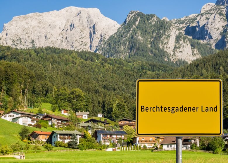 Ortsschild Berchtesgadener Land mit Bergen und Häusern