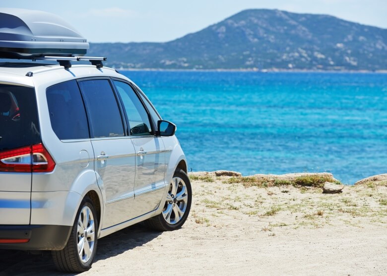 Silberner Minivan, Blick auf Meer und Berge