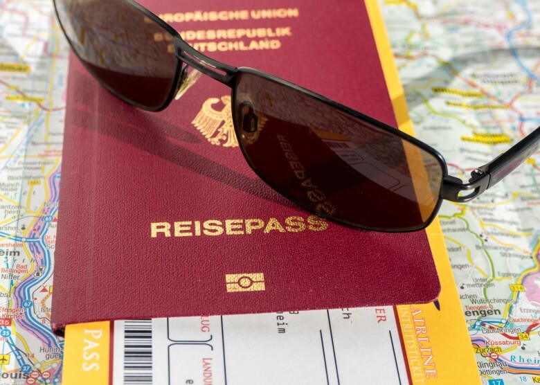 Reisepass, Flugticket und Sonnenbrille auf Weltkarte