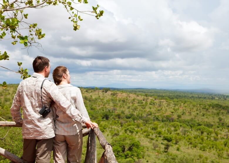 Pärchen in Safari-Kleidung blicken in die Ferne